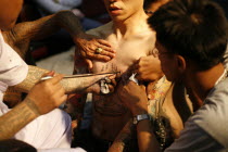 Man having tattoo applied to torso.Asian Southern Ecology Entorno Environmental Environnement Green Issues Male Men Guy Prathet Thai Raja Anachakra Thai Siam Southeast Asia