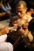 Man having tattoo applied to torso.Asian Southern Ecology Entorno Environmental Environnement Green Issues Male Men Guy Prathet Thai Raja Anachakra Thai Siam Southeast Asia