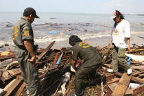 Tsunami. Rescue workers help to collect the bodies which have been floating out at sea and lying along the coastline. Bodies that were out at sea now litter the coastline. Now the devestation can be s...