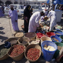 Local people in souk spice stall with spices in baskets and in bins.Market Middle East Omani