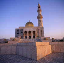 Zawawi Mosque. Exterior seen at dusk with gold dome shining and fountain in the foreground.Middle East Omani Religious Religion