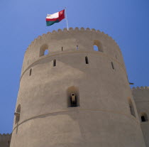 Fort.  Round tower with cannons in walls and Omani flag flyingHajr History Middle East Hajar