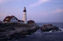 Portland Head Lighthouse. Waves crashing against rocks seen at dusk in warm light.American New England North America Northern Scenic United States of America Great Britain Northern Europe UK United K...