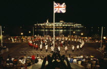 Band of the Bermuda Regiment performing Beat the Retreat a musical call under spotlight which derives from a British Army tradition.Bermudian Performance West Indies Public Presentation