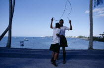 Schoolgirls playing with skipping rope.Bermudian Kids Learning Lessons Teaching West Indies