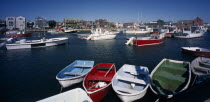 View over painted wooden rowing boats towards waterside buildings.New England North America United States of America American Great Britain Northern Northern Europe Scenic UK United Kingdom