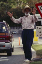 Local character Johnny Barnes at roadside laughing and throwing his hands up in the air.Bermudian One individual Solo Lone Solitary West Indies 1 Single unitary