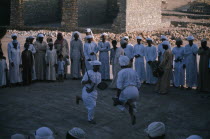Traditional dancing watched by group of men and childrenClassic Classical Historical Kids Male Man Guy Middle East Older Omani History Male Men Guy