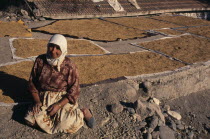 Kizilcahamam.  Woman sitting beside rice spread out to dry on rooftop.European Farming Agraian Agricultural Growing Husbandry  Land Producing Raising Female Women Girl Lady Middle East One individual...