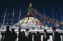 Pilgrims circling clockwise around Bodhanath Stupa draped with prayer flags during Loshar  the Tibetan New YearAsia Asian Nepalese Religion Religious
