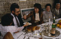 Jewish New Year.  The chala or bread is passed along table during festival meal in family home. European Great Britain Kids Northern Europe Religion Religious Judaism Jew Jews UK United Kingdom