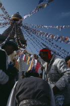 Tibetans hanging stupa with prayer flags during new year celebrations.Bodnath Asia Asian Bodhnath Nepalese Religious