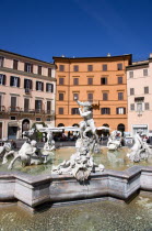 The Fountain of Neptune or Fontana del Nettuno in the Piazza Navona with tourists walking past restaurants beyondEuropean Italia Italian Roma Southern Europe Gray History Holidaymakers Religion Touri...