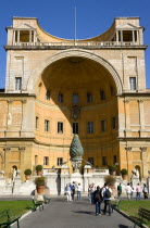 Vatican City Museum The central niche designed by Pirro Ligorio in the Belvedere palace housing the Cortile della Pigna a giant bronze pine cone from an ancient Roman fountain with tourists walking in...