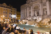 The 1762 Trevi Fountain by Nicola Salvi illuminated at night with tourists in the Piazza Di TreviEuropean Italia Italian Roma Southern Europe Holidaymakers Nite Tourism