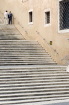 Two men talking in conversation on steps beside the Palazzo dei Conservatori on the CapitolEuropean Italia Italian Roma Southern Europe 2 Male Man Guy Male Men Guy