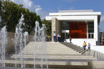 The fountain and steps with sightseers leading to the building hosuing the Ara Pacis or Altar of Peace built by Emperor Augustus to celebrate peace in the Mediteranean. The red prespex cube is part of...