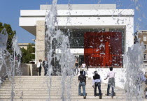 The fountain and steps with sightseers leading to the building hosuing the Ara Pacis or Altar of Peace built by Emperor Augustus to celebrate peace in the Mediteranean. The red prespex cube is part of...