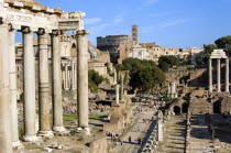 Tourists in the Forum with from left the columns of the Temple of Saturn  the Temple of Antoninus and Faustina  the Temple of Romulus  the Colosseum  the church and belltower of Santa Francesca Romana...