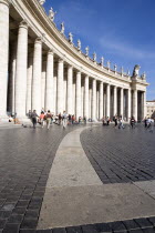 Vatican City Tourists in St Peters Square beside the curving colonnade by BerniniEuropean Italia Italian Roma Southern Europe Catholic Principality Citta del Vaticano Gray Holidaymakers Papal Religio...