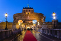 ITALY, Rome, Lazio, The fortress of Castel Sant Angelo illuminated at night with a red carpet laid across the bridge of Ponte Sant Angelo for an evening reception.