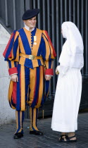Vatican City A Swiss Guard in full ceremonial uniform dress talking to a nun dressed in whiteEuropean Italia Italian Roma Southern Europe Catholic Principality Citta del Vaticano Papal Religion Relig...