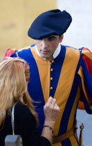 Vatican City A Swiss Guard in full ceremonial uniform dress talking to a female touristEuropean Italia Italian Roma Southern Europe Catholic Principality Citta del Vaticano Holidaymakers Papal Religi...