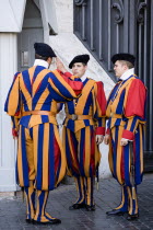 Vatican City Three Swiss Guards in full ceremonial uniform dress with two saluting each otherEuropean Italia Italian Roma Southern Europe 2 3 Catholic Principality Citta del Vaticano Gray Papal Relig...