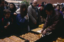 Food stall during Chinese New Year celebrations in Chinatown  Soho.   Diverse  racially mixed crowd.Chinese communitysociety Asian European Great Britain Londres Northern Europe UK United Kingdom Br...
