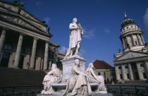 The Friedrich Schiller Memorial statue by Reinhold Begas in front of the Konzerthaus home of the Berlin Symphony Orchestra with Franzosischer Dom part seen on right.sculpture poet poetry Schauspielh...