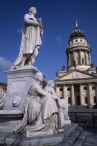 The Friedrich Schiller Memorial statue by Reinhold Begas in front of the Konzerthaus home of the Berlin Symphony Orchestra with Franzosischer Dom on right.sculpture poet poetry Schauspielhaus French...