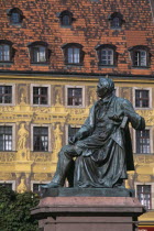 Detail of building facade with tromp l oeil painted mural.  Seated statue of writer Alexander Fredo in foreground. optical illusion realityliterature sculpture Eastern Europe European Polish Polska...