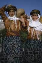 Three quarter portrait of two girls carrying gourd vessels.2 3 European Immature Middle East Turkish Turkiye Western Asia Asian Young Unripe Unripened Green