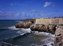 Peniche. Atlantic Ocean town. Sea and cliffs topped by part of curtain wall to the 16th Century Fortaleza Castle situated south of the town.European Portuguese Scenic Southern Europe Castillo Castell...