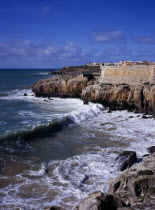 Peniche. Atlantic Ocean town. Sea and cliffs topped by part of curtain wall to the 16th Century Fortaleza Castle situated south of the town.European Portuguese Scenic Southern Europe Portugese Castil...