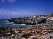 Peniche. Atlantic Ocean town. View across low cliffs and rocky foreshore towards the south side of  town with colourful painted houses European Portuguese Scenic Southern Europe Portugese Colorful