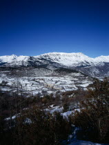 Snow covered mountain Macizo de Posets which is 3369 metres 11033 feet high point. The border with France on the right skyline. Trees in the foreground.AragoneseEuropean Scenic Southern Europe Espai...