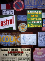 A collection of enamelled advertising signs seen on a garage door. Small blue and white sign which refers to Somerset and Dorset Railway.Loire ValleyEuropean Scenic French Western Europe