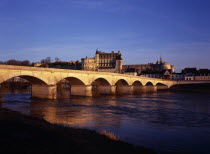 Chateau at Amboise and bridge seen from the flowing River Loire. Viewed in the evening with golden light.Loire Valley European Scenic French Western Europe Warm Light