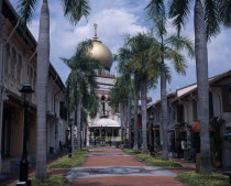 Road lined with palm trees leading to the Sultan Mosque with large gold dome. North Bridge Road.Asian Singaporean Singapura Southeast Asia Xinjiapo Northern Religious Religion