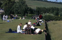 Opera attendees enjoying picnics in the gardens during interval.Picnicking European Great Britain Northern Europe Performance UK United Kingdom British Isles Public Presentation