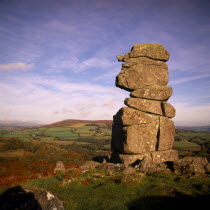Bowerman s Nose.  Dramatic granite tor shaped like face in profile with moorland landscape and hills beyond.  Bracken and trees in Autumn colours.rural countyside seasons seasonal European Great Brit...