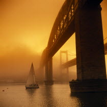 Royal Albert Bridge designed by Brunel and finished in 1859.  Spans the River Tamar between Plymouth and Saltash. Yacht passing below.Isambard Kingdom Brunel Nineteenth Century 19th C. Cornish Main L...