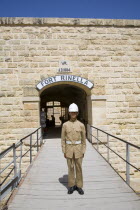 Soldier standing outside entrance to Fort RinellaTravelTourismHolidayVacationExploreRecreationLeisureSightseeingTouristAttractionTourDestinationTripJourneyDaytripFortRinellaKalkaraM...