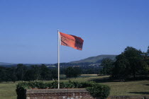 Red flag in the grounds of the country house and opera house looking out over green countrysideNear Lewes. European Great Britain Northern Europe Performance UK United Kingdom British Isles Public Pr...