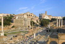 View of The Forum with the Colosseum rising behind the bell tower of the church of Santa Francesca Romana with tourists and the Temple of The Vestals and the three Corinthian columns of the Temple of...
