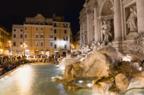 The 1762 Trevi Fountain by Nicola Salvi illuminated at night with tourists in the Piazza Di TreviEuropean Italia Italian Roma Southern Europe History Holidaymakers Nite Tourism