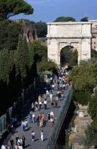 Tourists walking along the Via Sacra towards the Arch of Titus at the entrance to the ForumEuropean Italia Italian Roma Southern Europe History Holidaymakers Tourism