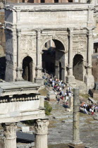Tourists walking through the centre of the triumphal Arch of Septimius Severus in the ForumEuropean Italia Italian Roma Southern Europe Center Gray History Holidaymakers Tourism