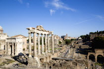 View of The Forum with the Colosseum rising behind the bell tower of the church of Santa Francesca Romana with tourists and the Arch of Septimius Severus on the left and the columns of the Temple of S...